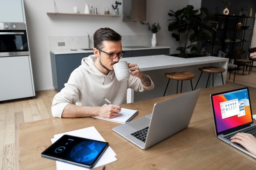 man working from home desk while having drink (1)